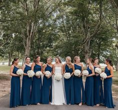 a group of women standing next to each other in front of tree's and grass