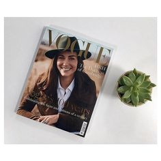 a magazine sitting next to a potted plant on top of a white countertop