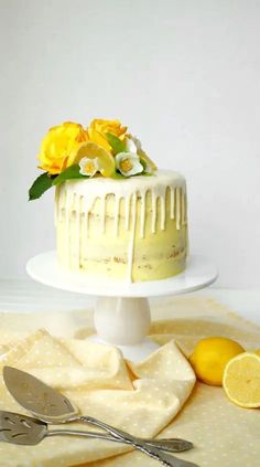 there is a cake with lemons and flowers on the table next to two forks