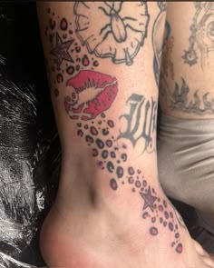 two people with tattoos on their legs and feet, one has a red lipstick tattoo