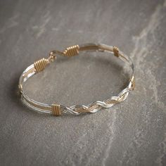 a gold and silver bracelet on a stone surface