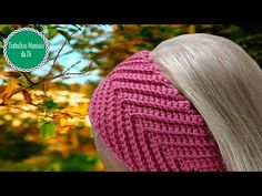 a woman with blonde hair wearing a pink knitted hat