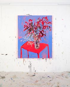 a painting on a wall with a red table and flowers