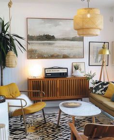 a living room filled with lots of furniture and art on the wall next to a coffee table