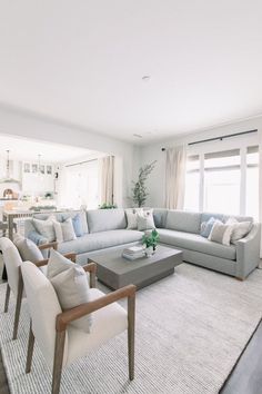 a living room filled with lots of furniture next to a kitchen and dining room table