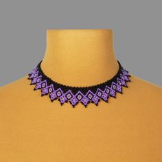 a purple and black beaded necklace on a mannequin neckline with beads