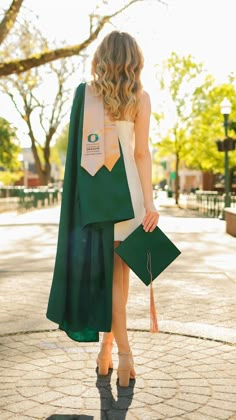 a woman in a green cape is walking down the street with her hand on her hip