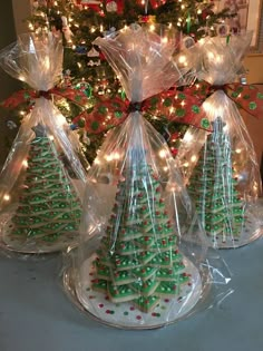 three bags filled with christmas trees sitting on top of a table next to a christmas tree