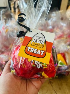 a hand holding a bag of candy with the label jesus is sweeter than any treat