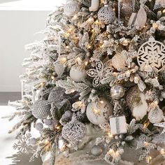 a decorated christmas tree with silver and white ornaments