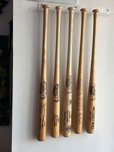 four wooden baseball bats hanging on the wall