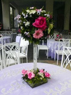 there is a vase with flowers in it on top of a table at a wedding