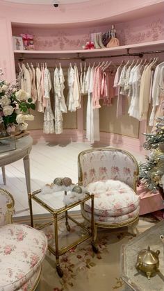 a room filled with lots of pink furniture and clothes hanging on the rack in front of it