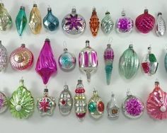 an assortment of christmas ornaments displayed on a white surface