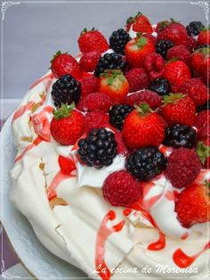 a cake with white frosting and berries on top