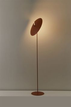 a lamp that is on top of a wooden stand in front of a white wall