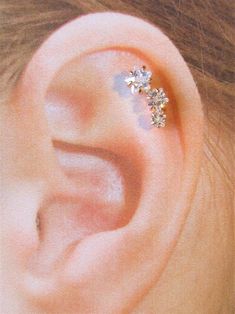 a woman's ear with three small flowers on it