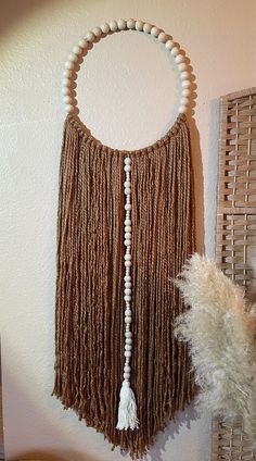 a wall hanging with beads and tassels on it