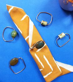 an assortment of rings, bracelets and other items laid out on a blue surface