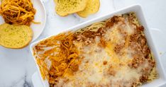 a casserole dish with cheese and meat in it on a marble counter top