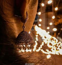 a close up of a person's ear with lights in the background