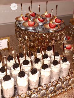 an assortment of desserts are displayed on a platter with spoons and forks