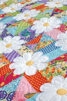 a colorful quilt with white flowers on it