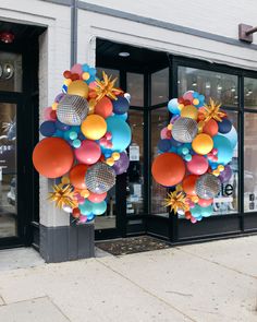 a bunch of balloons hanging from the side of a building