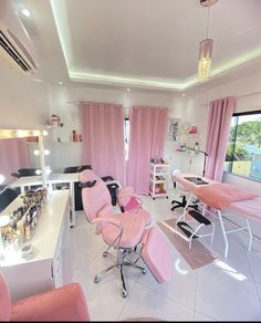 a salon with pink chairs and lights on the ceiling, windows in the room are open