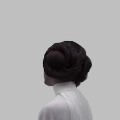 the back of a woman's head wearing a white shirt and black hair in a bun