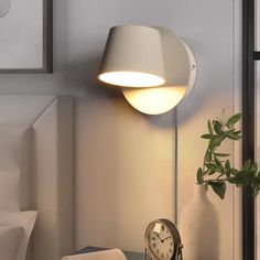 a lamp that is on top of a table next to a clock and some towels