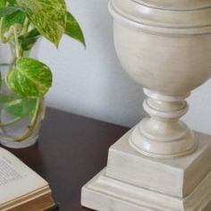 an open book sitting on top of a table next to a vase