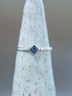 a white gold ring with a blue sapphire stone