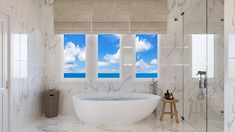 a large white bath tub sitting in a bathroom next to two windows with blue sky and clouds