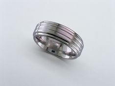 a wedding band with three rows of silver in the middle on a white background,