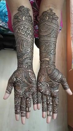 two hands with henna tattoos on them