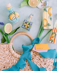 the contents of a wicker bag laid out on a blue surface with lemons