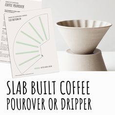 a coffee cup sitting on top of a table next to a paper with the words slab built