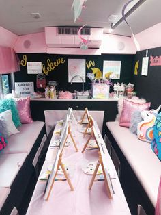 a party bus is decorated with pink and black decor, such as white couches