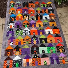 a quilt made to look like houses with halloween decorations on the top and bottom half