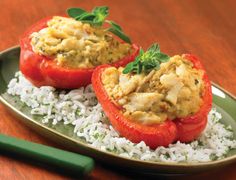 two stuffed tomatoes with rice on a plate