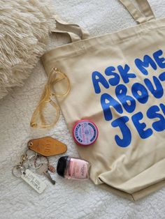 Ask Me About Jesus Christian Tote Bag. Say goodbye to plastic, and bag your goodies in this organic cotton tote bag. There's more than enough room for groceries, books, and anything in between. Tote Bag Info: * 100% certified organic cotton 3/1 twill * Fabric weight: 8 oz/yd² (272 g/m²) * Dimensions: 16″ × 14 ½″ × 5″ (40.6 cm × 35.6 cm × 12.7 cm) * Weight limit: 30 lbs (13.6 kg) * 1″ (2.5 cm) wide dual straps, 24.5″ (62.2 cm) length * Open main compartment * Blank product components sourced from Eco-friendly Cream Canvas Bag As Gift, Eco-friendly Cream Canvas Bag Gift, Eco-friendly Cream Canvas Bag For Gifts, Eco-friendly Cotton Canvas Bag For Personal Use, Christian Bag Ideas, Eco-friendly Canvas Bag With Letter Print, Painted Tote Bag Ideas Christian, Rose Salve, Bible Verse Tote Bag Painting