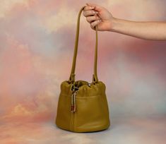 We know you. You want to carry a cute, mini bag, but you also want to fit everything in it. We can relate! Stop leaving your things at home, and start carrying the Duo bag. Not only is it large enough to fit your wallet, phone, sunglasses, and lots of accessories, this leather bucket bag has a drawstring and clasped strap so you can wear it lots of ways. In fact, that’s why we call it Duo! Our two strap settings allow for you to wear it shorter as a chic wristlet or wear it as a slouchy shoulder Handheld Bucket Bag With Removable Pouch For Travel, Handheld Bucket Bag With Detachable Handle For Travel, Chic Everyday Bucket Bag With Cell Phone Pocket, Versatile Handheld Bucket Bag For Travel, Modern Handheld Bucket Bag For Travel, Trendy Handheld Phone Bag For Everyday, Handheld Bucket Bag With Dust Bag, Everyday Handheld Bucket Bag With Detachable Strap, Chic Everyday Bucket Bag With Mobile Phone Bag