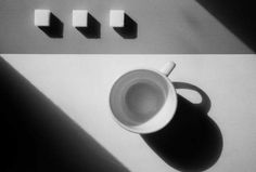 a coffee cup sitting on top of a table next to four blocks of magnets