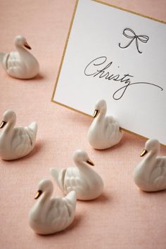 small white ducks sitting on top of a table next to a sign that says giving