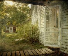 an old house with the door open in front of it