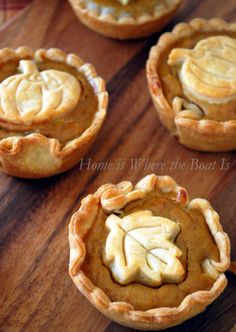 four pumpkin pies on a wooden table