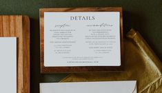 the wedding stationery is laid out on top of gold paper and wooden boxes with matching envelopes