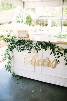 the reception table is decorated with greenery and gold letters