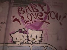 graffiti on the side of a building with two hello kitty characters